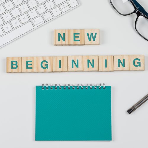 New start and business concept with wooden blocks, glasses, keyboard, pen, notebook on white background flat lay.