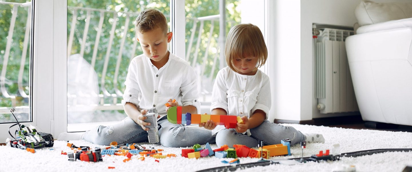 Brother and sister in a playing room. Children playing with a lego