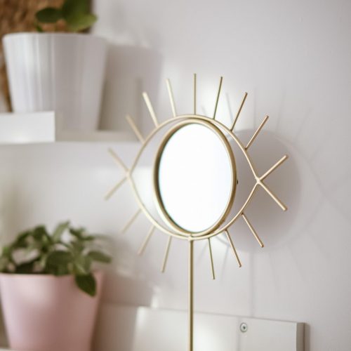 A vertical shot of a mirror with a shape of an eye