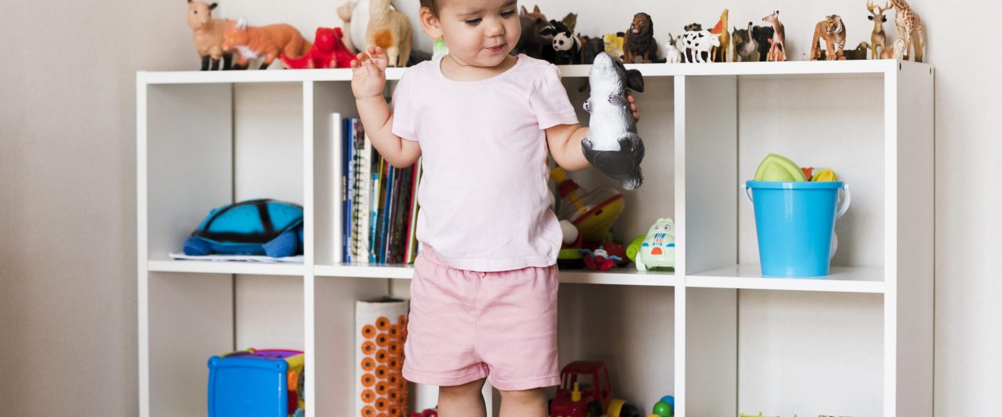 vue-de-face-de-l-heureux-petit-garcon-mignon-jouant-avec-des-jouets